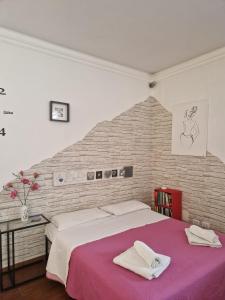 - une chambre avec un grand lit et un mur en briques dans l'établissement A casa di Delia - stazione Fidene, à Rome