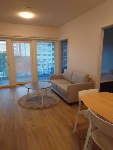 ein Wohnzimmer mit einem Sofa und einem Tisch in der Unterkunft Uusi korkea tasoinen kaksio, ilmastointi in Turku