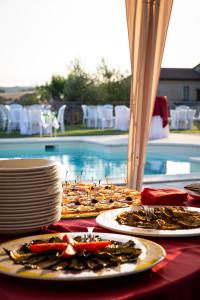 einen Tisch mit Teller mit Speisen neben einem Pool in der Unterkunft Agriturismo Il Tiro in Castel del Piano