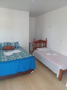 a bedroom with two beds in a room at Pousada da Rotatória in São Gonçalo do Amarante