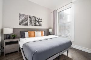 sypialnia z dużym łóżkiem i oknem w obiekcie Plateau Prime Residence w Montrealu
