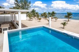 uma grande piscina azul junto à praia em White Sands Beach House em Maya Beach