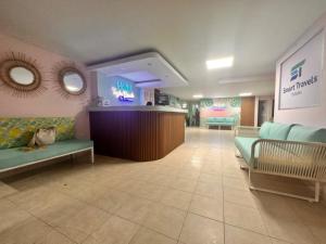 una sala de espera con sofás y un bar en un hospital en Taybo Beach By St Hoteles, en Santa Marta