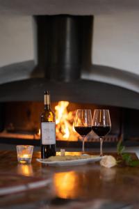 two glasses of red wine next to a bottle of wine at Finca Es Cabàs in Santa Maria del Camí