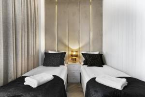 2 Betten in einem kleinen Zimmer mit Röcken in der Unterkunft Water Harmony Chmielna in Danzig