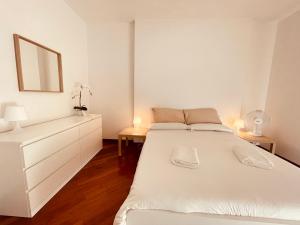 1 dormitorio blanco con 1 cama blanca y 2 lámparas en Lemon Tree Resort - FreeParking - Garden, en Génova