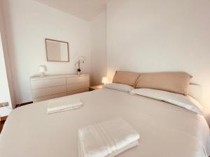 Una cama blanca con dos toallas encima. en Lemon Tree Resort - FreeParking - Garden, en Génova