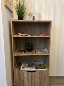 una estantería de madera con libros y revistas en Le Cocon Moulinois, proche gare avec services by PRIMO C0NCIERGERIE, en Moulins
