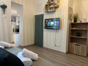 a living room with a flat screen tv on a wall at Le Cocon Moulinois, proche gare avec services by PRIMO C0NCIERGERIE in Moulins