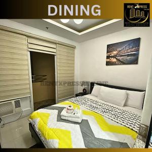 a bedroom with a bed with a yellow and white blanket at Near US Embassy - Free Sauna & Pool Access + 20% Off Promo This Month! Explore Deluxe Studio Unit in Manila w/ Balcony Perfectly Situated Near NAIA Airport, Heart of Manila - Updated 2023 Price for Your Unforgettable Ultimate Staycation Experience! in Manila