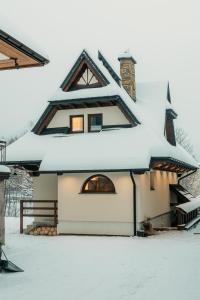 a house covered in snow on top of it at Domek na Wilczniku in Zakopane