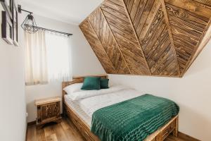 ein Schlafzimmer mit einem Bett mit einer großen Holzwand in der Unterkunft Domek na Wilczniku in Zakopane