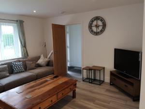 a living room with a couch and a coffee table at Cornish Coastal Bungalow in Padstow