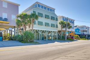 a building on the side of a street with palm trees at Beachfront Murrells Inlet Home - Walk to Pier! in Myrtle Beach