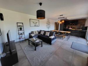 ein Wohnzimmer mit einem Sofa und einem Tisch in der Unterkunft Cottage chaleureux avec vue sur lac in Changey