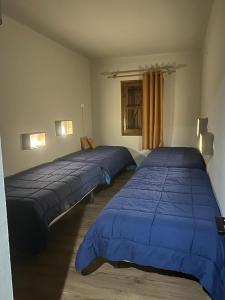 two beds in a bedroom with blue comforter at SOLDEU- EXCLUSIVO APARTAMENTO 130 M2 HASTA 10 PERSONAS CON PRECIOSAS VISTAS A PISTAS DE SKi in Soldeu
