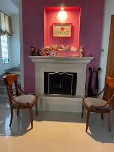a living room with two chairs and a fireplace at Fenix Villa in Noicattaro