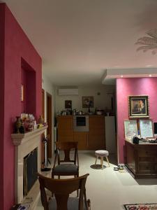 a living room with pink walls and a fireplace at Fenix Villa in Noicattaro