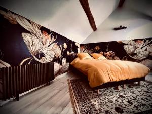 1 dormitorio con 1 cama y una pared con flores en Le Clos de L'Olivier, 