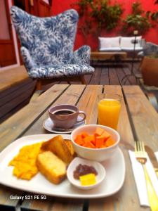 a plate of breakfast food on a wooden table at Hotel Caney Villa de Leyva by MH in Villa de Leyva