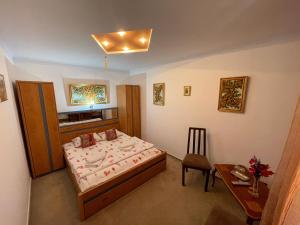a bedroom with a bed and a table and a chair at Casa Edan Breaza in Breaza