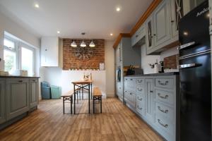 a kitchen with white cabinets and a table in it at Fairways View - Spacious Apartment - Sleeps 6 - Lovely Views in Hoylake