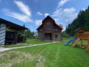 a house with a slide and a playground at Woodland House in Yaremche