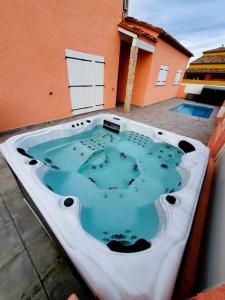 une grande baignoire jacuzzi installée au-dessus d'un bâtiment dans l'établissement Villa H2o - Jacuzzi & Piscine, au Barcarès