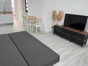 a living room with a flat screen tv and a table at Ataraxia Casa Vacacional in Mijas