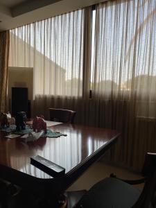 a wooden table in a room with a large window at Fenix Villa in Noicattaro