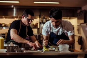 two men standing in a kitchen preparing food at Explora Valle Sagrado in Urubamba