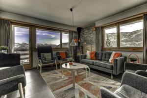 a living room with a couch and chairs and windows at Appartement Mont Parrain 4 in La Tzoumaz