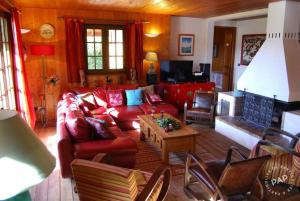 a living room with a red couch and a table at Les Castors in Villard-de-Lans