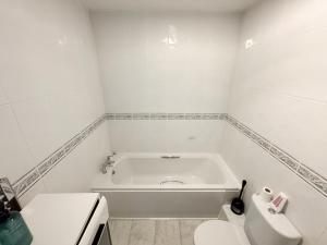 a white bathroom with a tub and a toilet at Perfect for Contractors - Long Term Discounts, Free Parking & Fast Wifi in Wolverhampton
