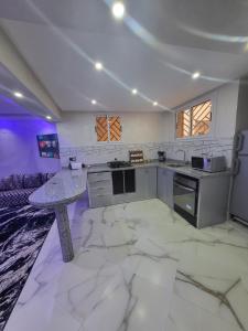 マラケシュにあるMagnifique appartement duplex à 5min de l'aéroport de Marrakechの大理石フロアの広いキッチン(テーブル付)
