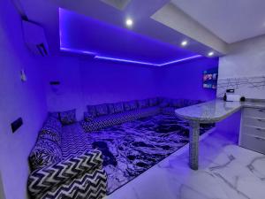 マラケシュにあるMagnifique appartement duplex à 5min de l'aéroport de Marrakechの紫色の部屋(ソファ、テーブル付)