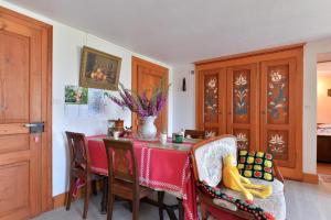 a dining room with a red table and chairs at Les Hirondelles in Orbey