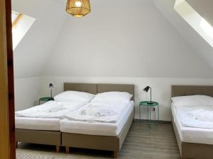 バンスカー・シュチャヴニツァにあるSiglisbergのベッド2台(白いシーツ、ランプ付)