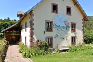 a house with a painting on the side of it at Les Hirondelles in Orbey
