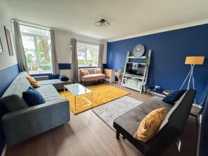 a living room with blue walls and a couch at Perfect for Contractors - Long Term Discounts, Free Parking & Fast Wifi in Wolverhampton