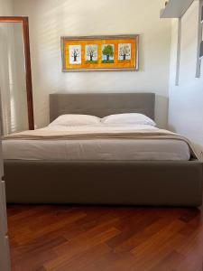 a large bed in a bedroom with a wooden floor at Fenix Villa in Noicattaro
