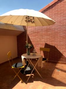 una mesa y sillas bajo una sombrilla blanca en INSIDEHOME Apartments - Palencia Centro, en Palencia