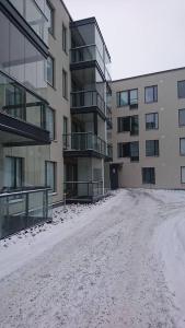 a snow covered street in front of a building at Studio Kakolanmäellä in Turku