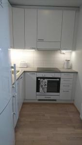 a kitchen with white cabinets and a stove top oven at Studio Kakolanmäellä in Turku