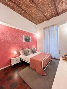 ein Schlafzimmer mit einem Bett und einer roten Wand in der Unterkunft Suite Scarlatti in Neapel