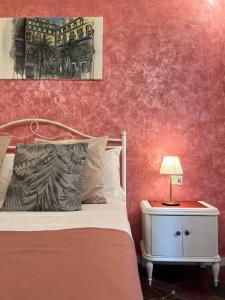 1 dormitorio con 1 cama y 1 mesa con lámpara en Suite Scarlatti, en Nápoles