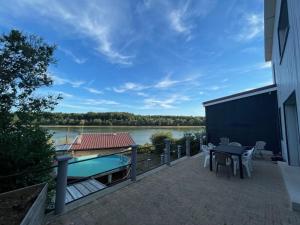 eine Terrasse mit einem Tisch und einem Boot auf dem Wasser in der Unterkunft Cottage chaleureux avec vue sur lac in Changey