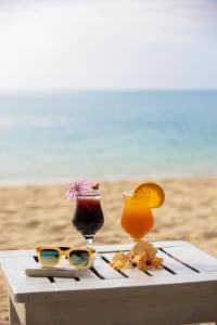un tavolo con due cocktail e bicchieri sulla spiaggia di Baansook Resort Koh Chang a Ko Chang