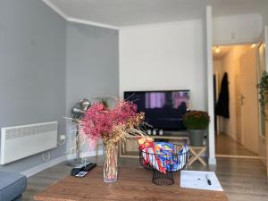 a vase of flowers on a table in a living room at Appartement Ostend in Ostend