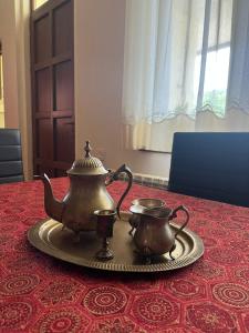 two tea pots on a tray on a table at Guest House Anuki in Sighnaghi
